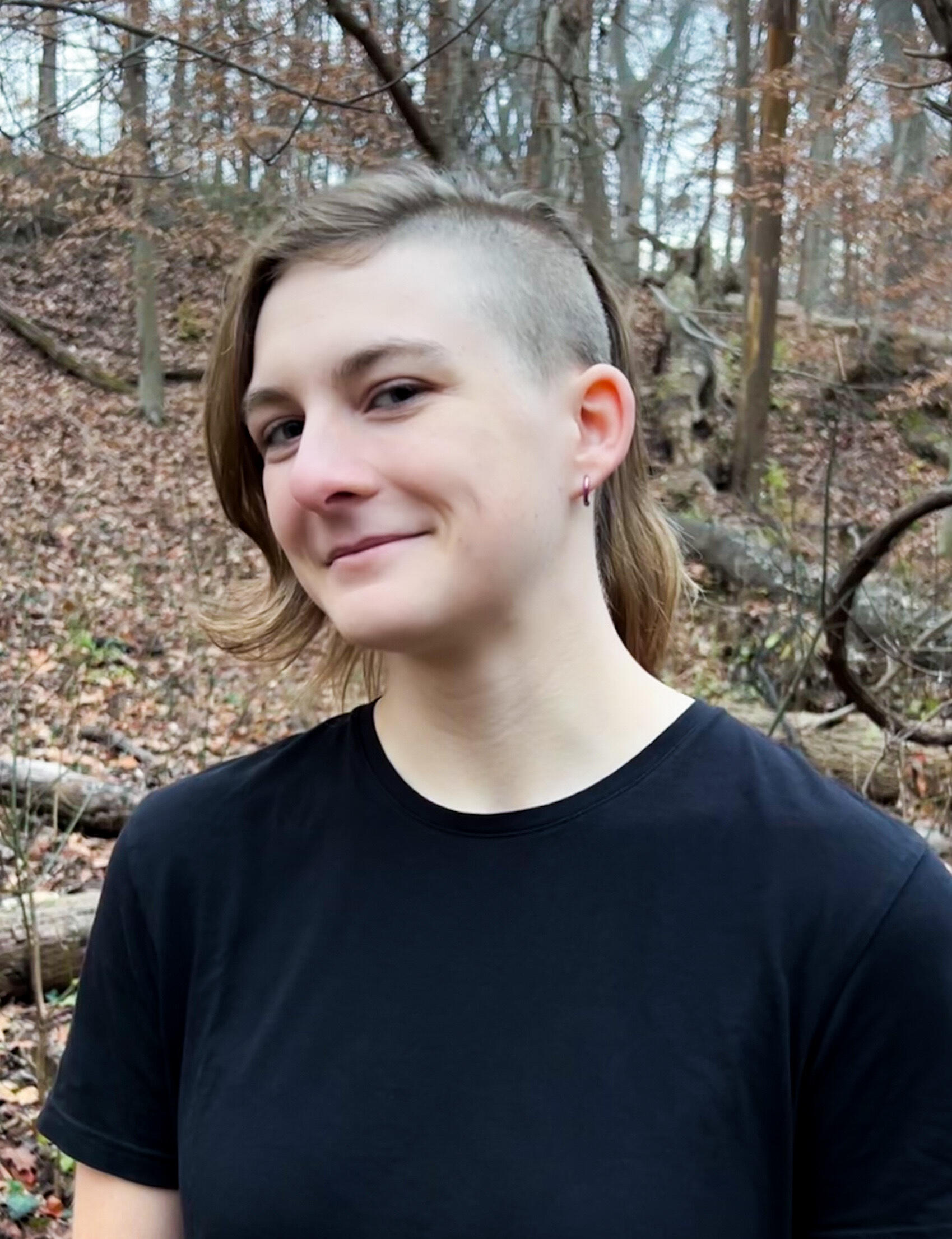 Mia Donalson smiling in a forested environment.