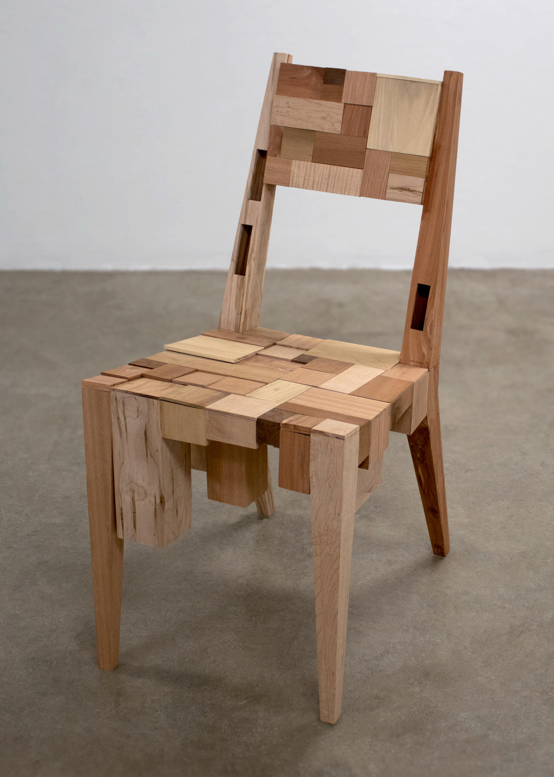 This is a wooden chair made by Mia Donalson. It is comprised of 50 boxes that each hold an object of importance.